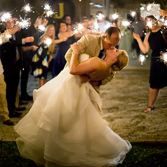 Couple kissing during their sparkler sendoff by Sparklers Online
